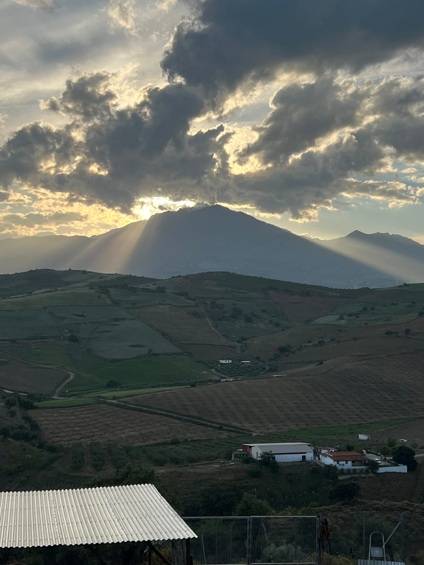 Sun rays breaking over the mountains above Málaga