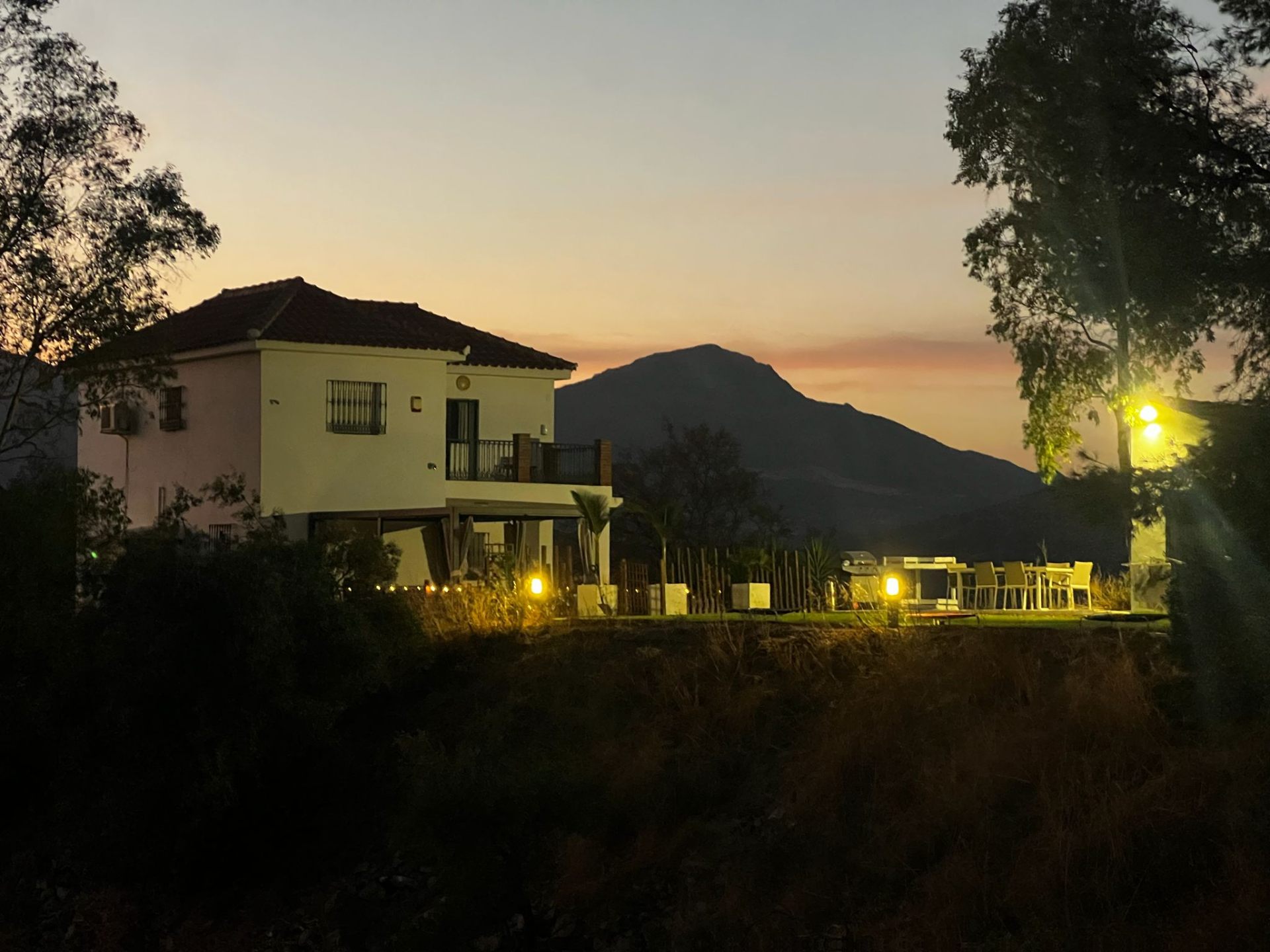 The Ridge property at dusk, mountain rising behind