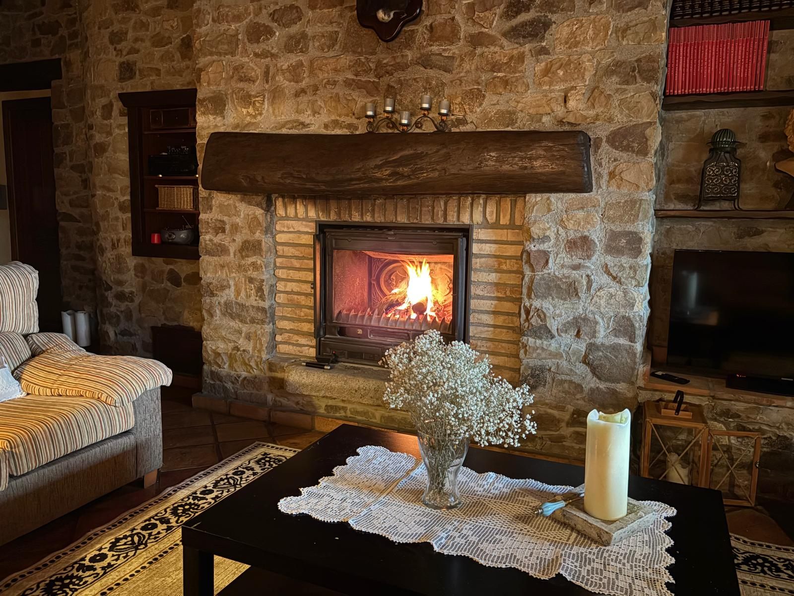 The property's stone fireplace and lounge, lit by firelight